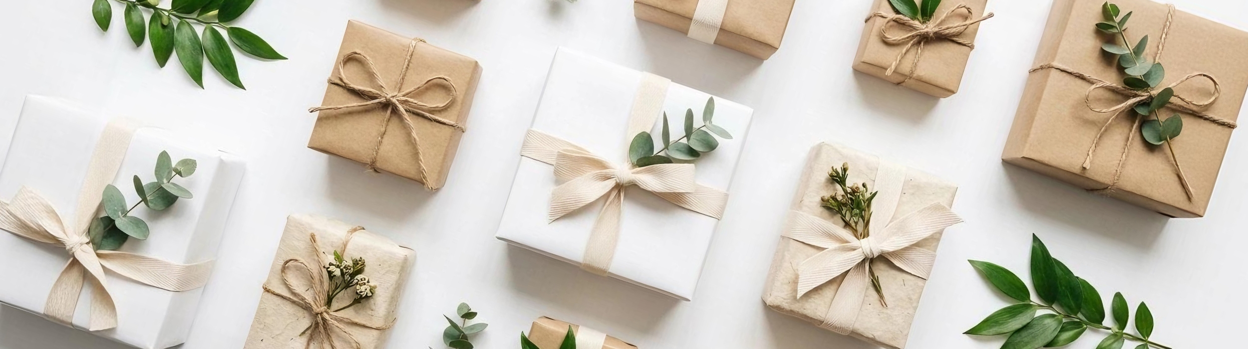 Cajas de regalos envueltas con papel kraft y decoradas con hojas y cuerda natural